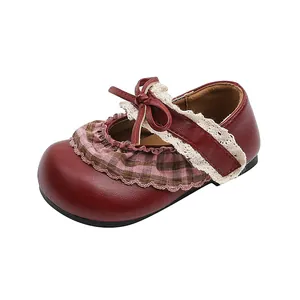 Nahaufnahme von roten Mädchen-Prinzessin-Schuhen mit Schleife, Spitze und Karomuster-Volant
