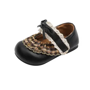 Detailaufnahme von schwarzen Mädchen-Mary-Jane-Schuhen mit kariertem Volant und Spitze