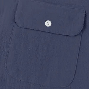 Primer plano detallado de la textura de lino azul marino y bolsillo de camisa con botón blanco