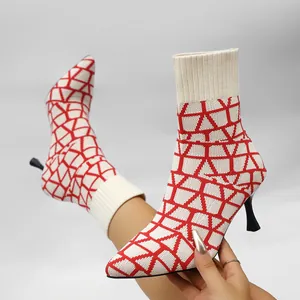 Detail of pointed-toe stretch ankle boots featuring a vibrant red geometric knit pattern
