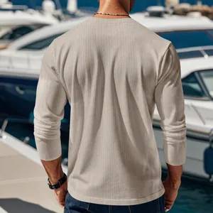 Back view of a men's beige ribbed long-sleeve casual shirt in a yacht marina scene.
