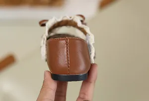 Detailansicht der Ferse und der Spitzenverzierung dieser braunen Mädchenlederschuhe
