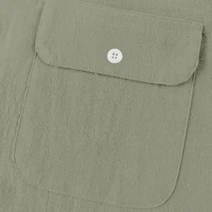 Primer plano detallado de bolsillo con botón blanco en camisa de lino verde salvia para hombre