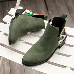 Primer plano de botines Chelsea de ante verde con bordados florales