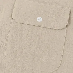 Primer plano detallado del bolsillo con botón blanco en camisa Henley de lino caqui