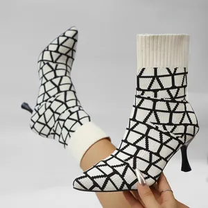 Close-up of pointed toe sock boots with black and white geometric pattern and thin heels