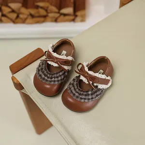 Detailansicht brauner Prinzessinnenschuhe für Mädchen mit Spitze und Schleife.