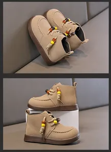 Detail von Retro-Kinder-Martens-Stiefeln in Khaki mit bunten Perlen und Gummisohlen
