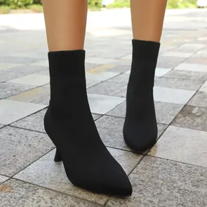 Close-up of black pointed-toe stretch knit boots with elegant stiletto heels.