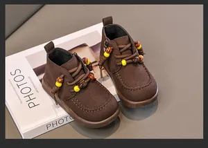 Nahaufnahme von braunen Retro-Kinderstiefeletten mit dekorativer Perlenverzierung