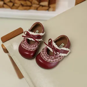 Detailansicht weinroter Mary Jane Kinderschuhe mit zarter Spitze und Schleifenakzenten