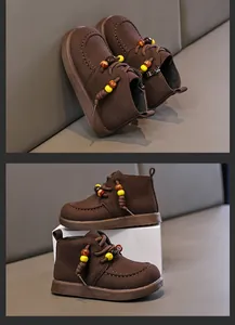 Detaillierte Ansicht von braunen Wildleder-Kinderschuhen mit gelben Zierperlen
