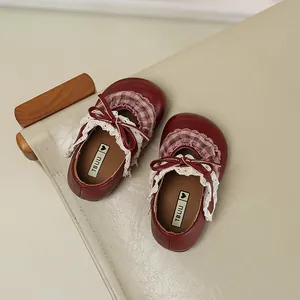Detailansicht der burgunderroten Mädchenschuhe mit rosa Karos und Spitzenbesatz.