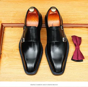 Top view detail of black leather double monk strap shoes with square toe and blue stitching