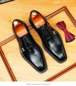 Detail view of square toe black leather monk strap shoes with blue stitching