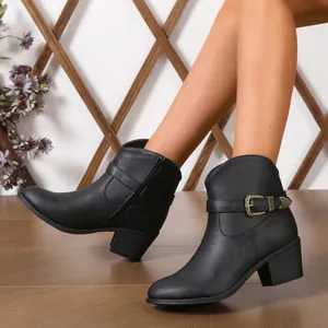 Detail von schwarzen Western-Stiefeletten mit Zierschnalle und Blockabsatz am Modell.