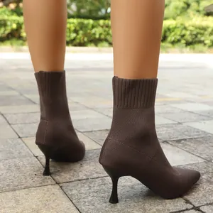 Close-up of brown pointed-toe stretch knit ankle boots with slim stiletto high heels.