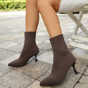Elegant brown knitted pointed-toe stiletto ankle boots shown in an outdoor setting