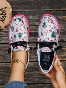 Women's Christmas print canvas loafers with pink soles and black laces shown in detail
