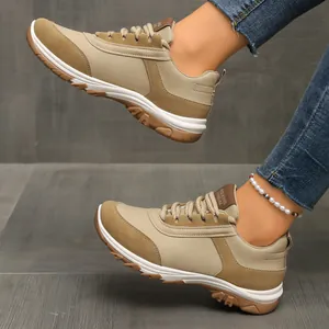Detailansicht der khakifarbenen Retro-Sneaker für Damen in Blockfarben mit Jeans.