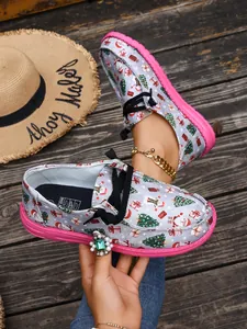Close-up view of women's Christmas print canvas loafers with vibrant pink flat soles.