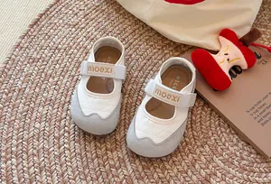 Draufsicht auf stylische creme-graue Mary Jane Sneaker für Mädchen auf einem Teppich.