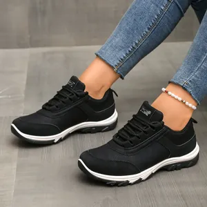 Schwarze Retro-Damen-Sneaker mit weißer Sohle getragen zu Jeans und Fußkettchen