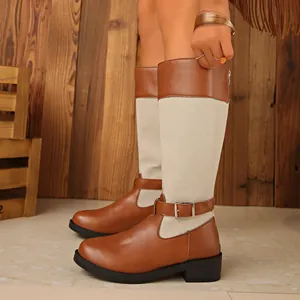 Detail of colorblock knight boots featuring brown leather and beige denim patchwork.