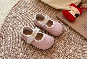 Detailansicht von rosa Mädchen-Sneakern im Mary-Jane-Stil auf einem Webteppich