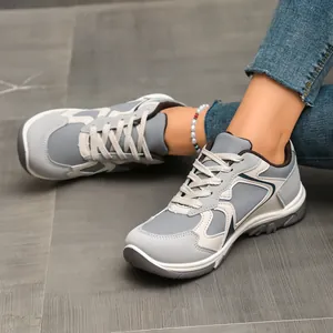 Nahaufnahme von Vintage-Sneakern in Farbkombination, getragen mit Jeans auf grauem Boden.