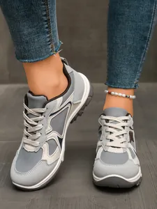 Retro-Sneaker für Damen mit Farbmuster in Grau und Creme, getragen zu einer blauen Jeanshose.