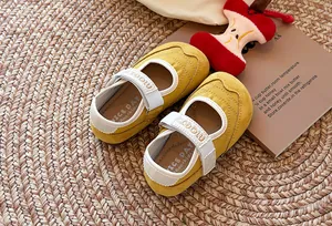 Detailansicht gelber Mary-Jane-Sneaker mit weicher Sohle für Kleinkinder auf einer Flechtmatte