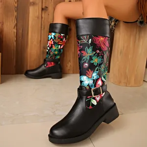 Detailed close-up of women's tall boots with colorful floral embroidery and buckle
