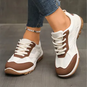 Detaillierte Nahaufnahme der Retro-Damen-Sneaker in Weiß und Braun mit Kontrastfarben