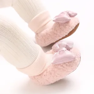 Detailed close-up of pink fluffy baby toddler shoes with a decorative satin bow detail