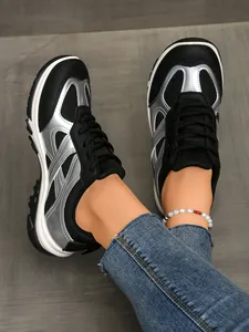 Nahaufnahme von stylischen schwarzen und silbernen Retro-Sneakern zu blauen Jeans