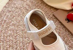 Detailansicht des moexi-Logos und des cremefarbenen Designs dieser Mary Jane Sneaker für Mädchen