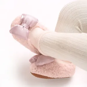 Detail view of pink plush baby girl walker shoes featuring a soft satin bow decoration