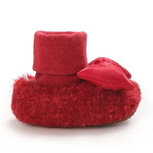Side view of red baby walker shoe with plush fleece and satin bow detail.