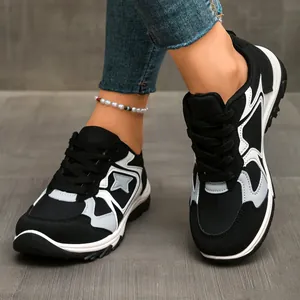 Nahaufnahme von Damen Retro-Sneakern in Schwarz-Weiß mit kontrastierendem Sterndesign-Detail
