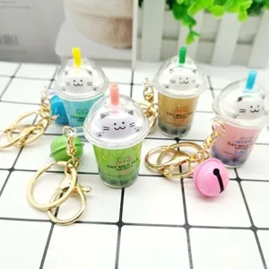 Detail showing four colors of creative cat milk tea cup keychains with bells