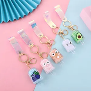 Detail of colorful popsicle glitter keychains with holographic straps and gold hardware.