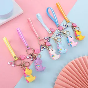 Colorful cartoon unicorn and dinosaur keychains with rainbow charms and wrist straps