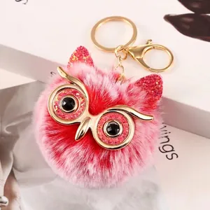 Charming pink faux fur owl pom-pom keychain featuring glitter ears and gold metal face