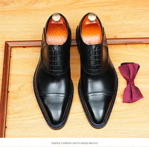 Chaussures Oxford en cuir noir élégantes pour hommes sur une surface en bois naturel.