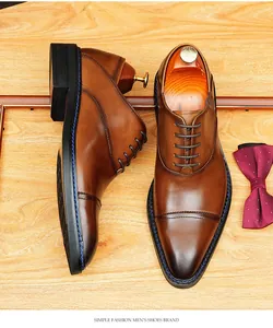Gros plan sur des chaussures Richelieu en cuir marron patiné avec surpiqûres bleues