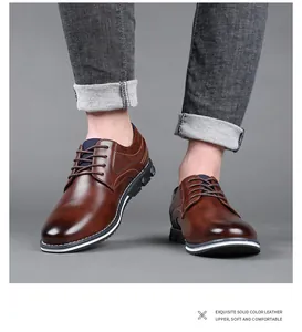 Detailed close-up of brown leather business casual shoes on a model wearing gray jeans
