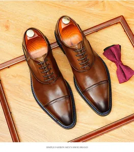 Vue détaillée de chaussures Oxford en cuir poli marron avec un élégant nœud papillon rouge