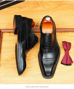 Chaussures Richelieu en cuir noir avec bout carré et détails brogues pour hommes d'affaires.