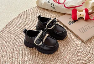 Nahaufnahme schwarzer Prinzessinnenschuhe für Mädchen mit Spitzenbesatz und Schleife.